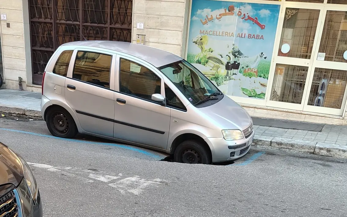 Reggio, auto incastrata in una voragine in pieno centro\n