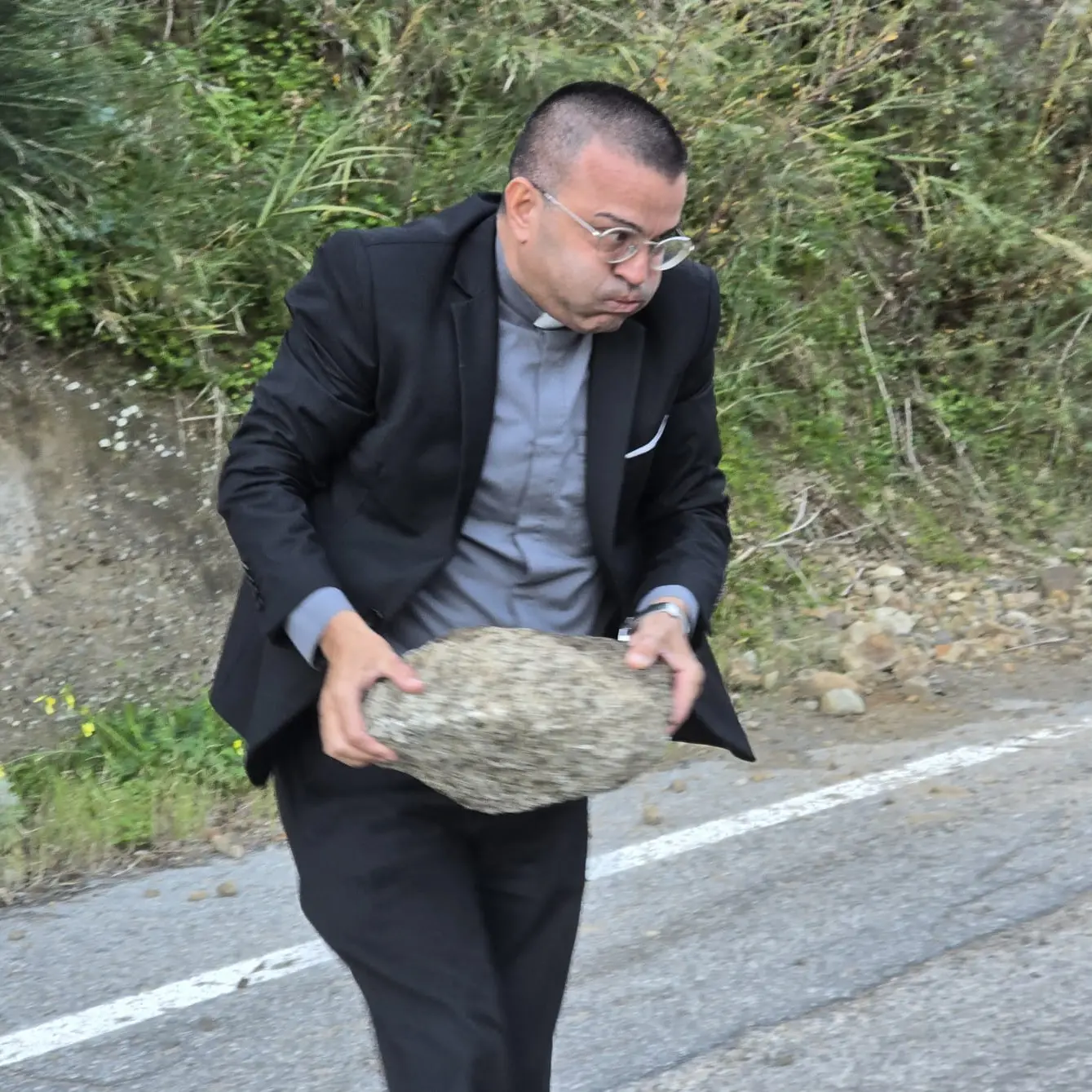 Montebello, frana sulla strada provinciale: don Giovanni Zampaglione dà l’esempio rimuovendo un masso\n