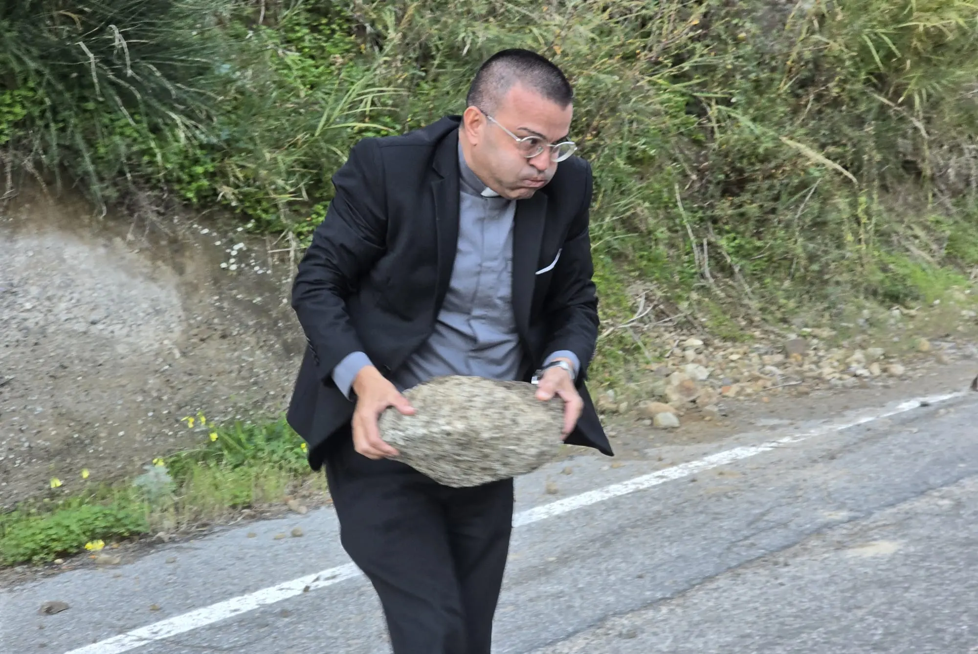 Montebello, frana sulla strada provinciale: don Giovanni Zampaglione dà l’esempio rimuovendo un masso\n