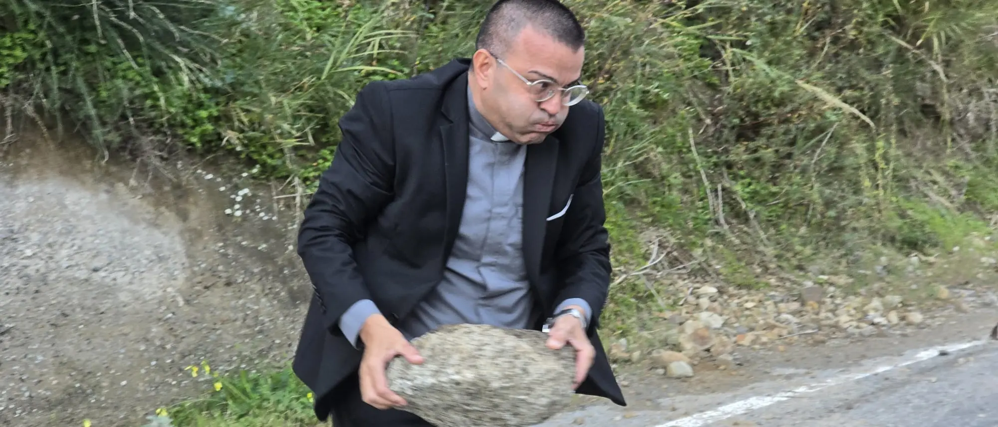 Montebello, frana sulla strada provinciale: don Giovanni Zampaglione dà l’esempio rimuovendo un masso\n