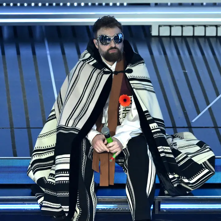 Dargen D’Amico nel mirino del Codacons: «Pubblicità occulta all’Ariston?», esposto all’Agcom per il fiore arancione\n