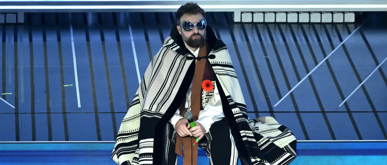 Dargen D’Amico nel mirino del Codacons: «Pubblicità occulta all’Ariston?», esposto all’Agcom per il fiore arancione\n