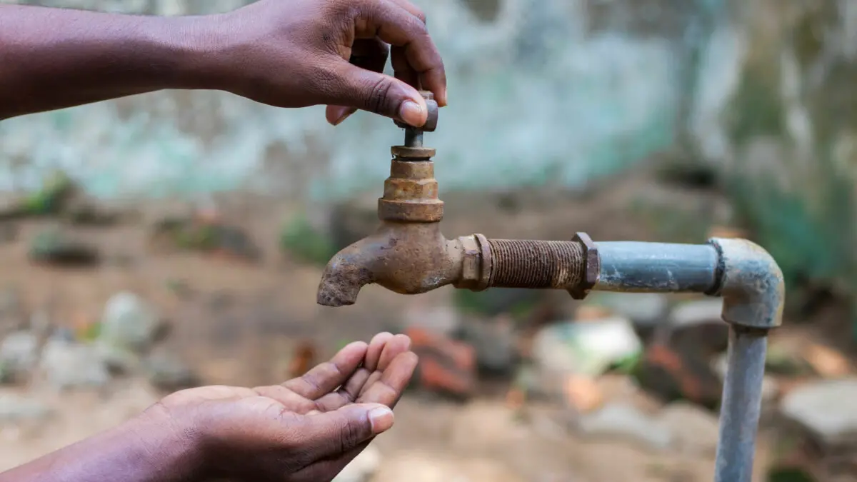 water crisis is a serious threat to India and worldwide,a man holding his hand under the tap for water , Shutterstock