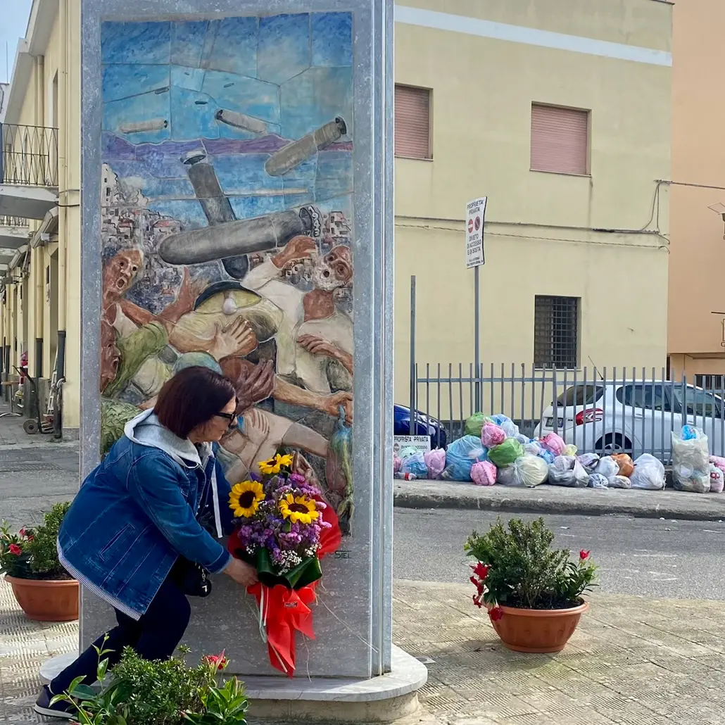 Un mazzo di fiori davanti alla stele e dietro una micro discarica: l’associazione Noi Santa Caterina commemora e si indigna\n