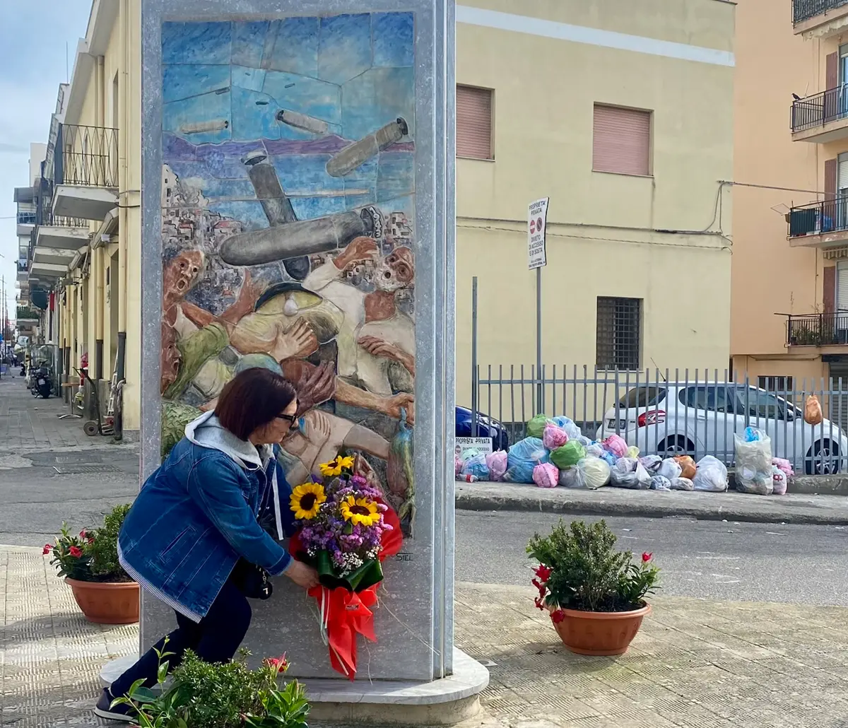 Un mazzo di fiori davanti alla stele e dietro una micro discarica: l’associazione Noi Santa Caterina commemora e si indigna\n