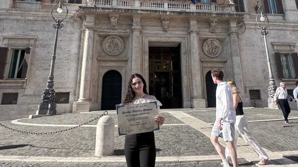 <p>Francesca Fazio con il Premio America Giovani davanti alla Camera dei deputati</p>\\n