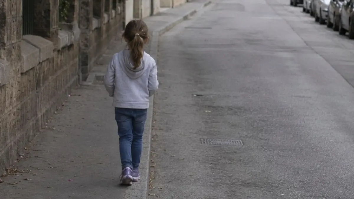 Bambina cammina per strada (AI)