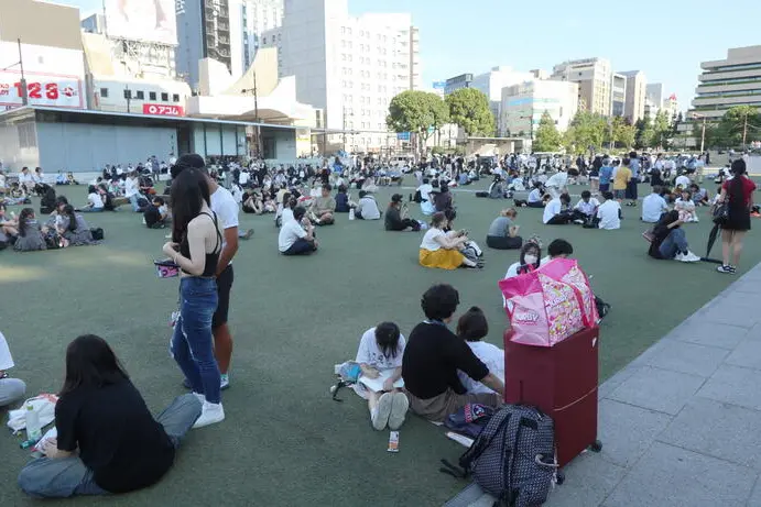 epa13136845 People gather outside a building following a powerful earthquake in Kumamoto City, Japan, 28 July 2026. According to the Japan Meteorological Agency, an earthquake of a magnitude estimated at 7.1 struck Kumamoto Prefecture, southwestern Japan. EPA/JIJI PRESS JAPAN OUT EDITORIAL USE ONLY/