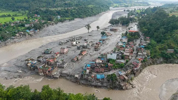 TOPSHOT - An aerial view shows houses lying deluged in sludge after flash floods at Devighat, Bidur Municipality in Nepal's Nuwakot district on August 27, 2026. Nepal's disaster agency said that 823 people remained out of contact on August 27, more than 24 hours after a deadly flood tore through the border region with Tibet. (Photo by Prabin RANABHAT / AFP)