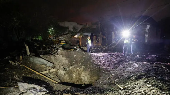 epa13321426 Ukrainian police officers inspect the crater at the site of a Russian missile strike on a private building in a residential area in Kyiv, Ukraine, 22 October 2026, amid the ongoing Russian invasion. At least five people were injured during the overnight massive ballistic missile attack, according to the Kyiv City Military Administration report. EPA/SERGEY DOLZHENKO , EPA